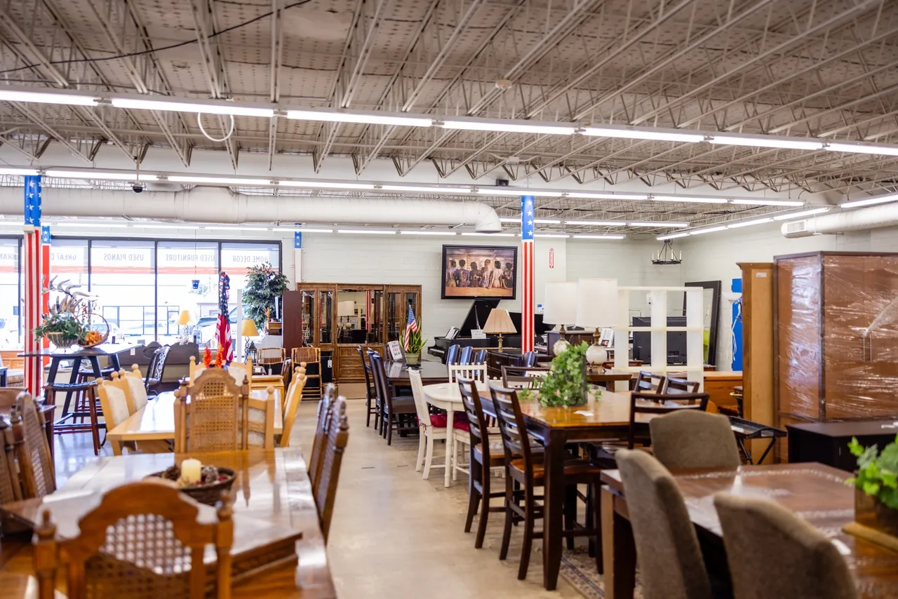 Furniture store interior with various tables displayed.